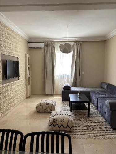 a living room with a couch and a table at Sublime T3 bord de mer avec piscine & Balcon I Proche Aéroport in Hajreien