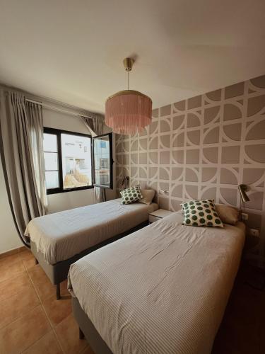 a bedroom with two beds and a chandelier at Blue Surf House Only surf in Corralejo