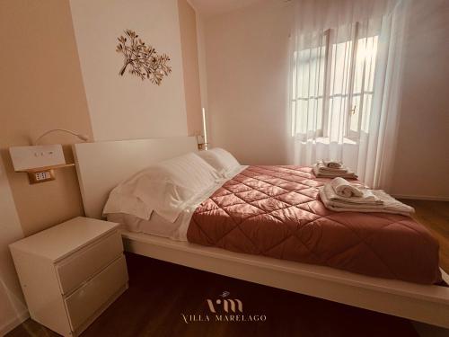 a small bedroom with a bed and a window at Villa Marelago Guest House in Lido Di Fondi
