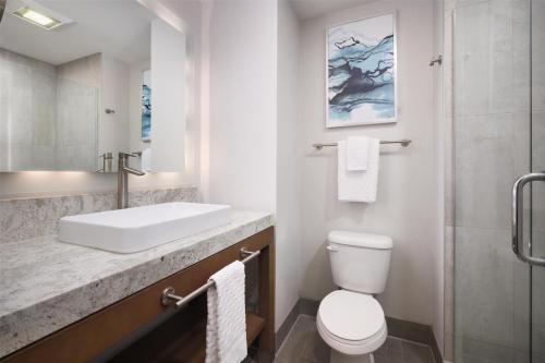 a bathroom with a sink and a toilet and a shower at Best Western Premier Hotel at Fisher's Landing in Vancouver