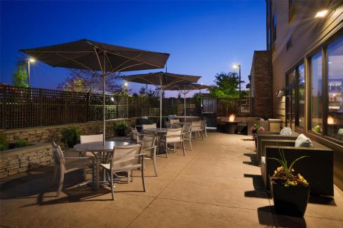 a patio with tables and chairs and umbrellas at night at Best Western Premier Hotel at Fisher's Landing in Vancouver