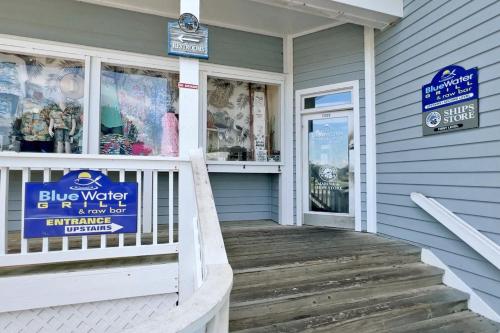 a blue house with a blue water sign on the door at Duck Crossing in Manteo