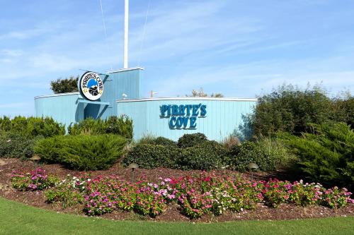 a sign for a sports club with flowers in a garden at Duck Crossing in Manteo
