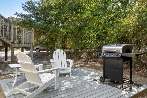 two chairs and a grill on a wooden deck at Easy Breezy in Duck
