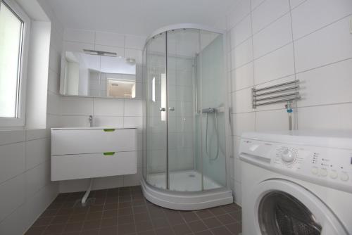a bathroom with a shower and a washing machine at Villa South Beach in Karlskrona