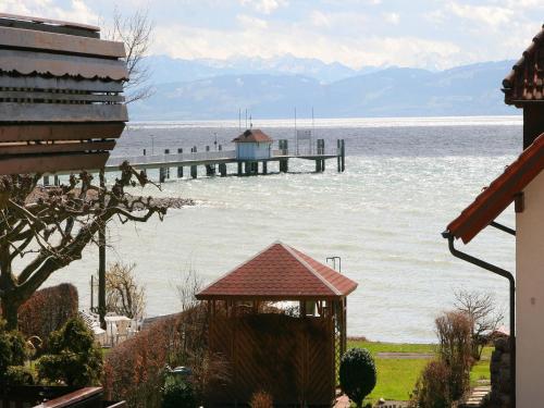 a view of a pier on the water with a house at Sommerhof Rauber in Immenstaad am Bodensee