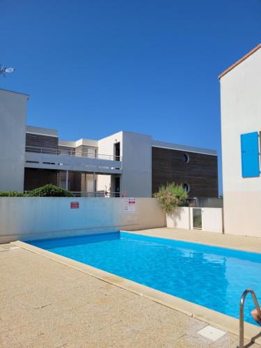 une piscine devant un immeuble dans l'établissement Appartement avec piscine et accès direct à la mer, à Châtelaillon-Plage