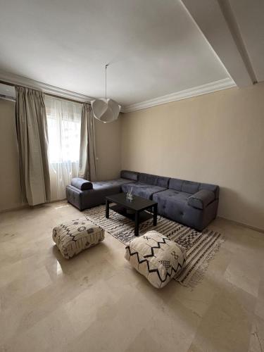 a living room with a couch and a table at Sublime T3 bord de mer avec piscine & Balcon I Proche Aéroport in Hajreien