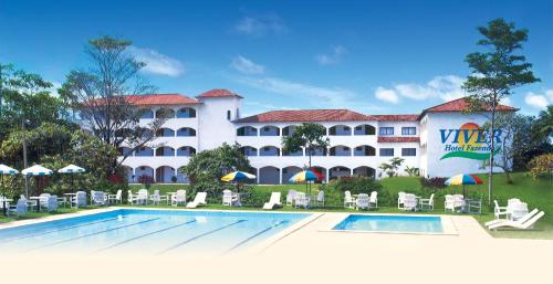 un resort con piscina, sedie e un edificio di Viver Hotel Fazenda a Moreno