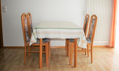 a table with four chairs and a table cloth on it at Sommerhof Rauber in Immenstaad am Bodensee