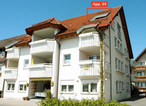 a white apartment building with a red roof at Sommerhof Rauber in Immenstaad am Bodensee