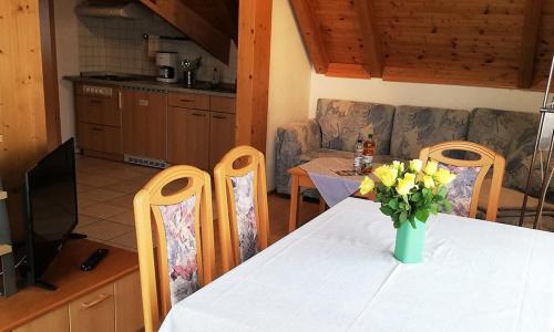 a kitchen with a table with a vase of flowers on it at Sommerhof Rauber in Immenstaad am Bodensee