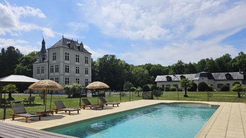 a house with a swimming pool in front of a building at Gîtes du Château de Malcombe in Rillé