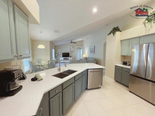 a large kitchen with a sink and a refrigerator at 35 - Relax & Play 4-Bed Villa with Pool & Game Room Minutes to Disney in Orlando