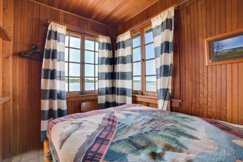 a bedroom with a bed and two windows at Fish, Boat and Swim Cedarville Gem 6 with Dock Access in Cedarville