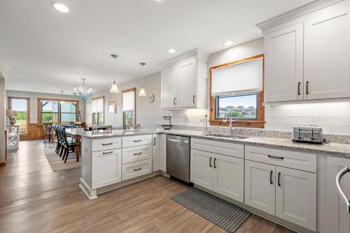 a kitchen with white cabinets and a dining room at Endless Summer in Sanderling