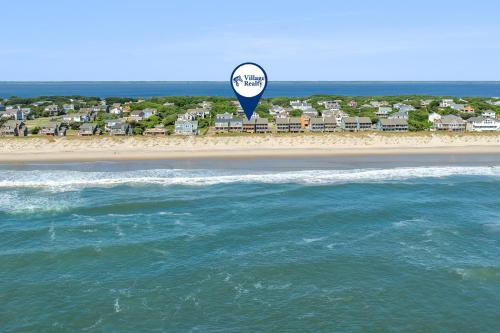 a kite is flying over a beach with houses at Endless Summer in Sanderling