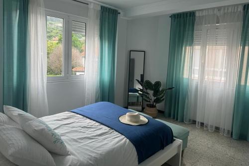 ein Schlafzimmer mit einem Bett, auf dem ein Hut liegt in der Unterkunft Piso céntrico cerca de la playa Cedeira in Cedeira