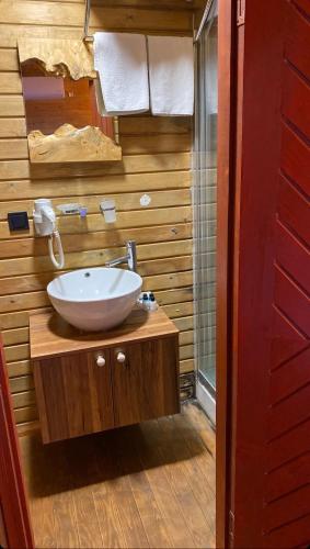 a bathroom with a white sink and a red door at Pamera Garden Hotel in Kılıçlı