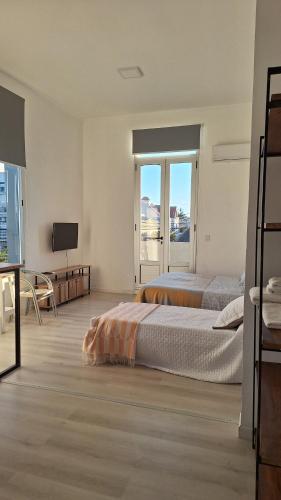 une chambre d'hôtel avec deux lits et une télévision dans l'établissement Departamentos Espejo Dpto A, à Concordia
