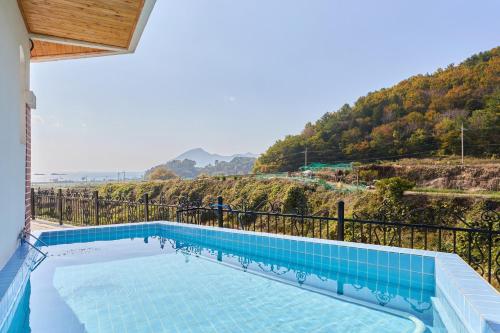 a swimming pool with a view of a mountain at Spain House in Namhae