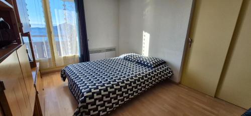 une chambre avec un lit dans une pièce avec une fenêtre dans l'établissement Prapoutel - Les 7 Laux, à Les Adrets