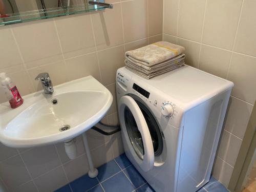 a washing machine and a sink in a bathroom at KURESSAARE TALLINN STREET APARTMENTs in Kuressaare