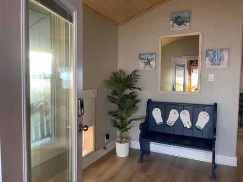 a blue bench in a room with a mirror and a plant at Suelen Bay House in San Leon