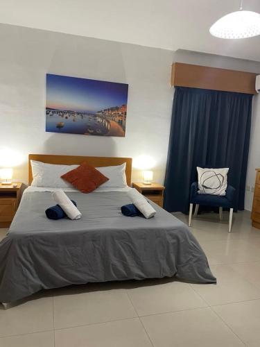 a bedroom with a large bed and a chair at Spacious Bugibba Seafront Villa Free Parking & WiFi in St. Paul's Bay