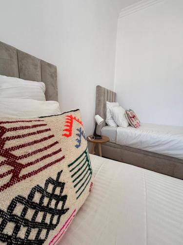 a bedroom with two beds and a blanket on the bed at Sublime T3 bord de mer avec piscine & Balcon I Proche Aéroport in Hajreien