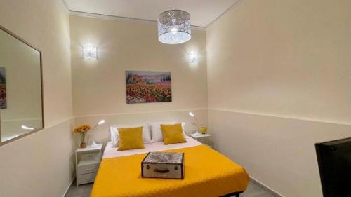 a bedroom with a yellow bed with a yellow blanket at Chez D'Ossuna - Cultura e Relax -10 minuti dalla Cattedrale in Palermo