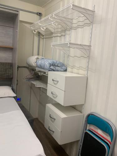 a bedroom with a bed and some drawers and shelves at Estúdios Conteiners de 02 a 04 hóspedes região lapa in Sao Paulo