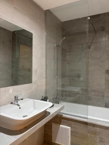 a bathroom with a sink and a glass shower at Sublime T3 bord de mer avec piscine & Balcon I Proche Aéroport in Hajreien