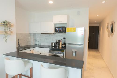 a kitchen with a stainless steel refrigerator and white cabinets at Brand new Caribbean getaway at CanaRock! in Punta Cana