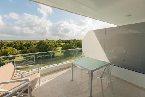 a glass table and chairs on a balcony with a view at Brand new Caribbean getaway at CanaRock! in Punta Cana
