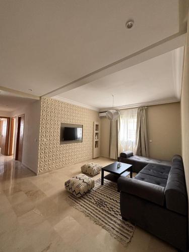 a living room with a couch and a table at Sublime T3 bord de mer avec piscine & Balcon I Proche Aéroport in Hajreien