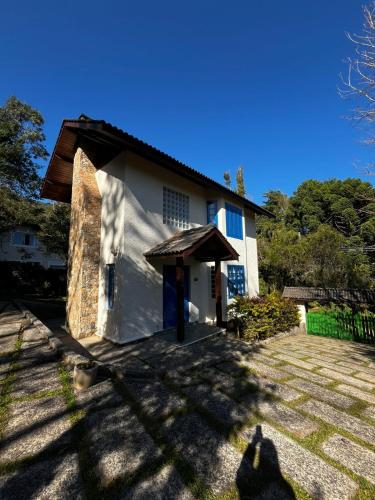 a white house with a brown roof at Chalé Igraine in Camanducaia