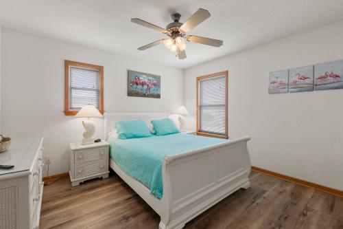 a bedroom with a bed and a ceiling fan at Flamingo Nest in Kill Devil Hills
