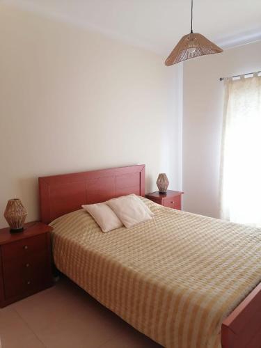 a bedroom with a bed with two night stands and a window at Casa Vila Rosa - T1 Altura Beach in Altura