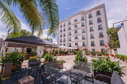 a hotel with tables and chairs in front of a building at HG Hotel in Guadalajara