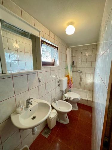 a bathroom with two sinks and a toilet at Cosy country home, Lendava in Lendava