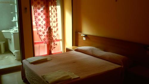 カオルレにあるHotel Cinziaのベッドルーム1室(ベッド1台付)、バスルーム(窓付)が備わります。
