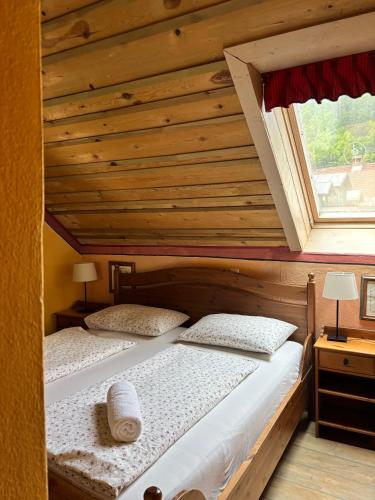 two beds in a room with a wooden ceiling at Apartments Belopeški Dvori in Kranjska Gora