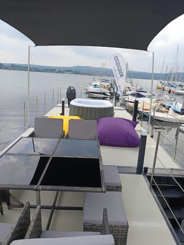a boat with chairs and tables on a dock with boats at DIAMOND Bigigio House Boat in Lisanza