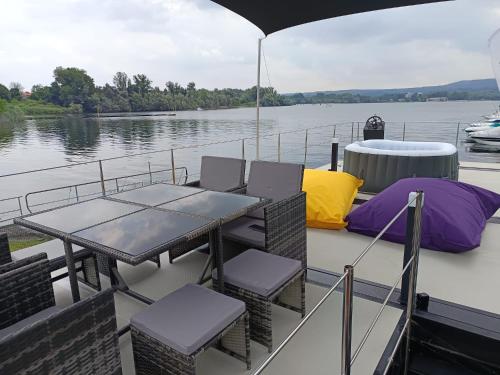a table and chairs on the deck of a boat at DIAMOND Bigigio House Boat in Lisanza