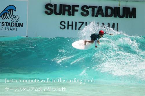 a person riding a wave on a surfboard in the ocean at Glam Pool Terrace Shizunami in Makinohara