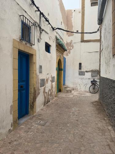 um beco com uma porta azul e uma bicicleta em Dar sidi laghazi em Essaouira