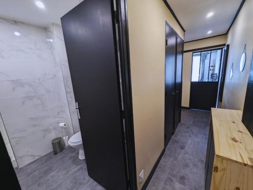 ein Badezimmer mit Toilette und schwarzer Tür in der Unterkunft Appartement chic et cosy au pied du village in Villard-de-Lans