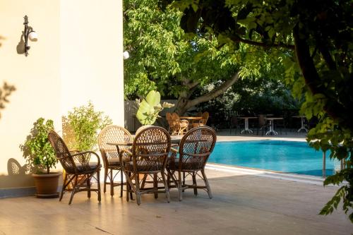 a group of chairs and a table next to a pool at Güneş Boutique Hotel - Oludeniz in Oludeniz