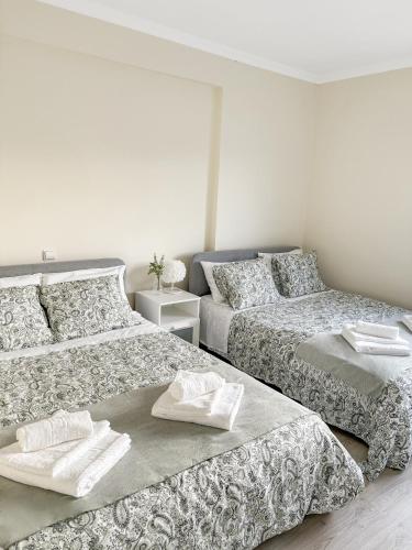 two beds sitting next to each other in a bedroom at GoldMar Beach Apartments - Praia da Vieira in Vieira de Leiria
